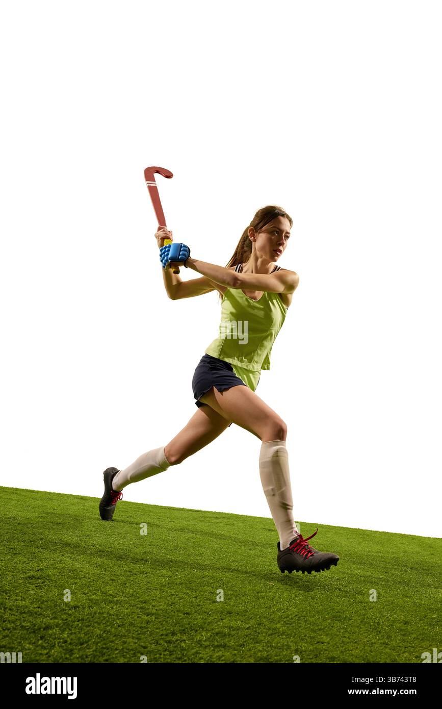 Der fokussierte Athlet lädt den nach vorne greifenden Stick fest auf das grüne Grasfeld vor weißem Studiohintergrund und zeigt die Bereitschaft für scharfes Gameplay. Stockfoto