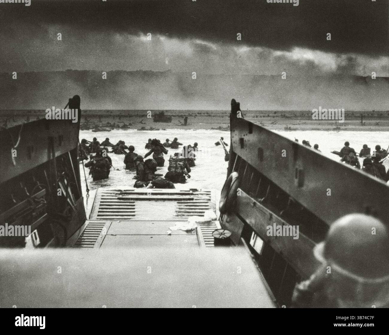 Männer des 16. Infanterieregiments waten an Land am Omaha Beach, während der Normandie während des 2. Weltkriegs in Frankreich landete. Stockfoto