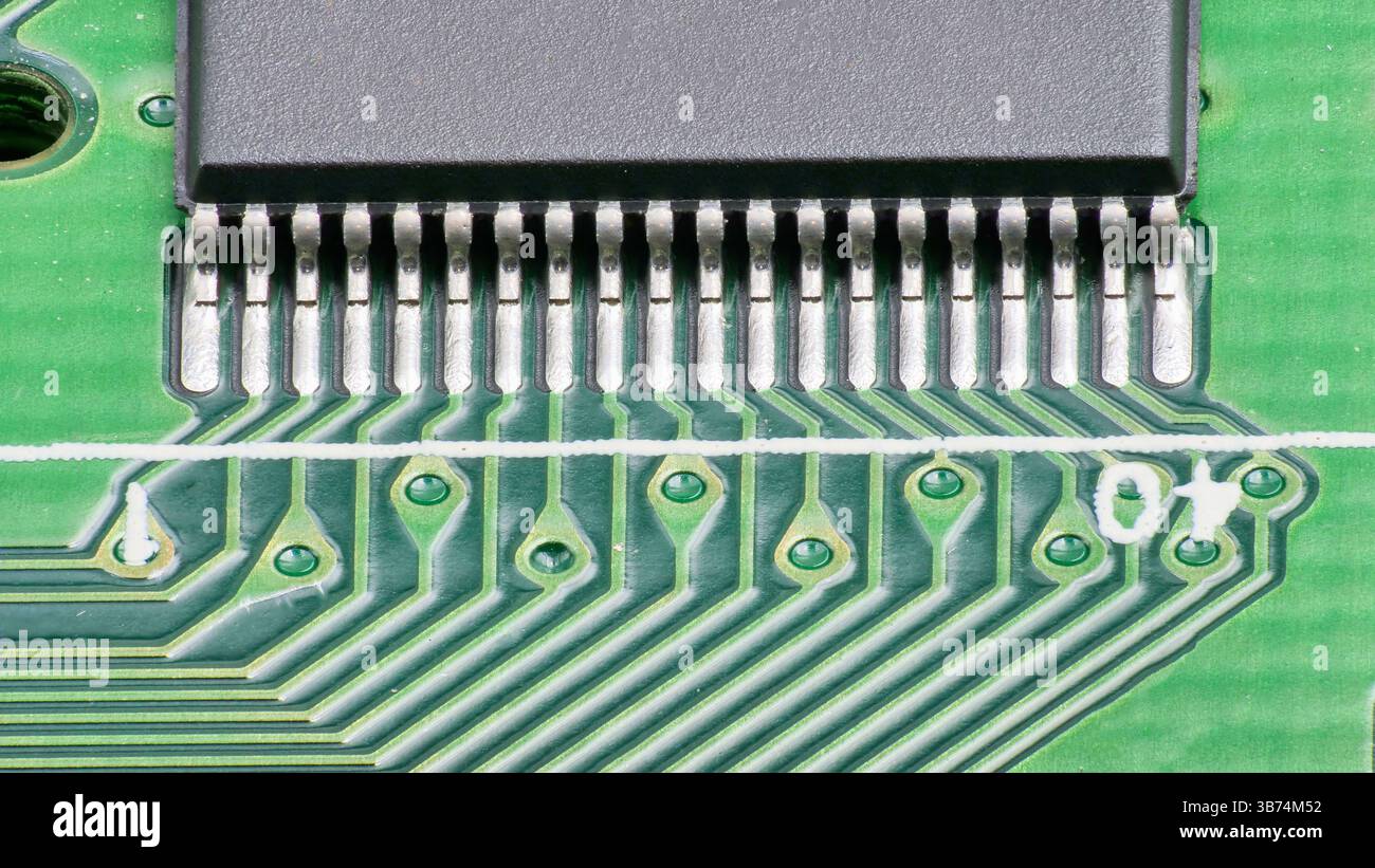 Ein detaillierter Blick auf eine Leiterplatte zeigt Metallkontakte und gedruckte Verbindungen und zeigt die Komplexität der elektronischen Montage bei einem Technologie-fa Stockfoto