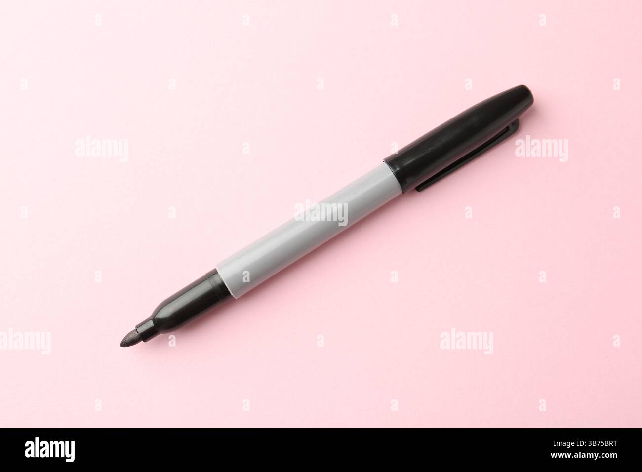 Ein schwarzer Marker auf hellrosa Hintergrund, Draufsicht Stockfoto