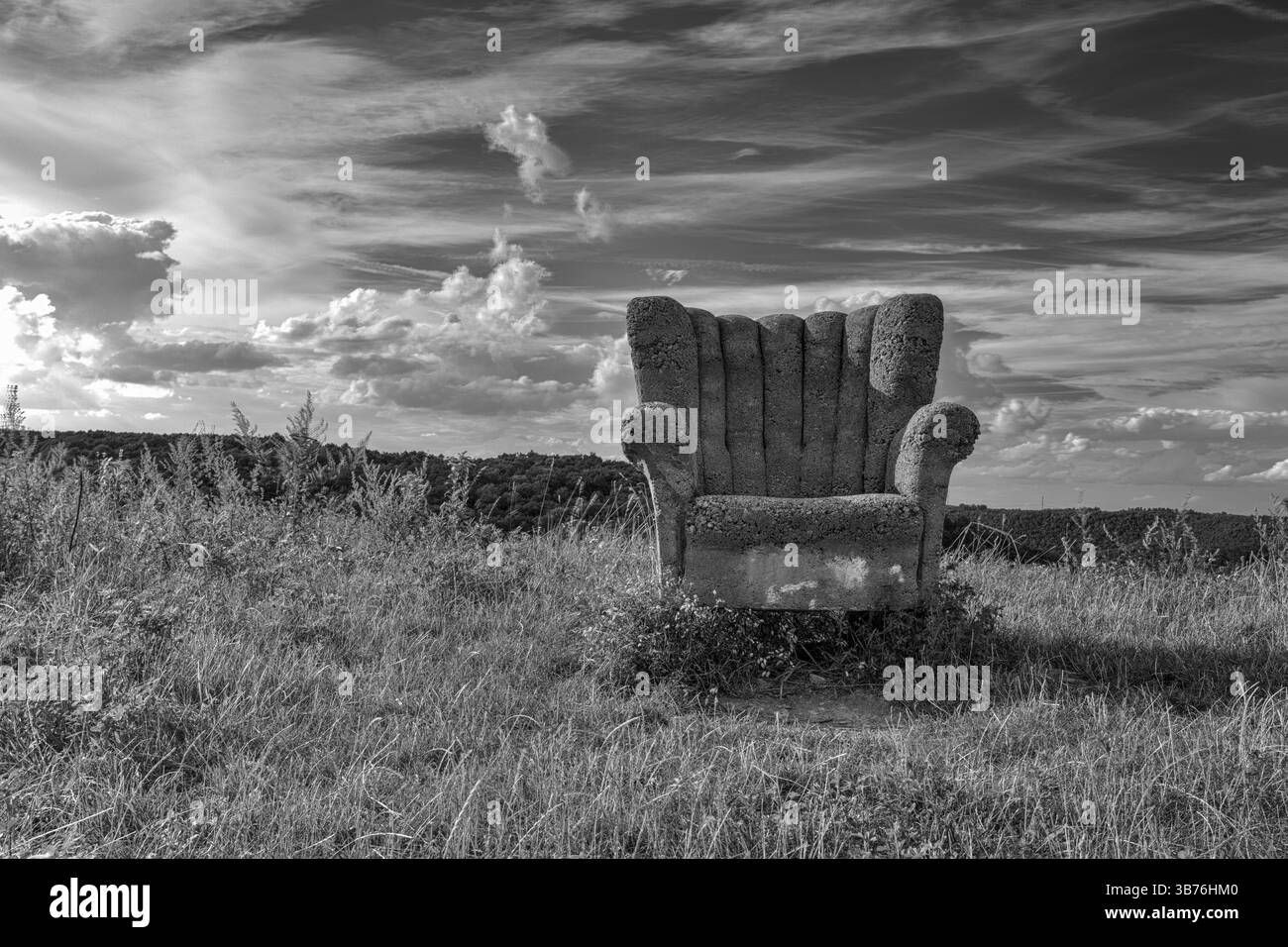 Verlassener Betonstuhl auf dem Hügel bei Sonnenuntergang Stockfoto