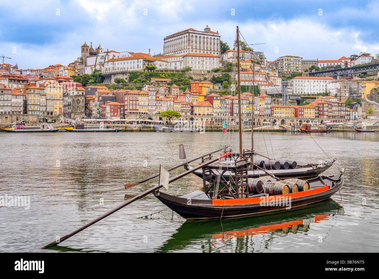 Farbenfrohe historische Boote, die traditionell für den Transport von Haftweinen verwendet wurden, fahren auf dem Fluss Douro in Porto, Portugal Stockfoto