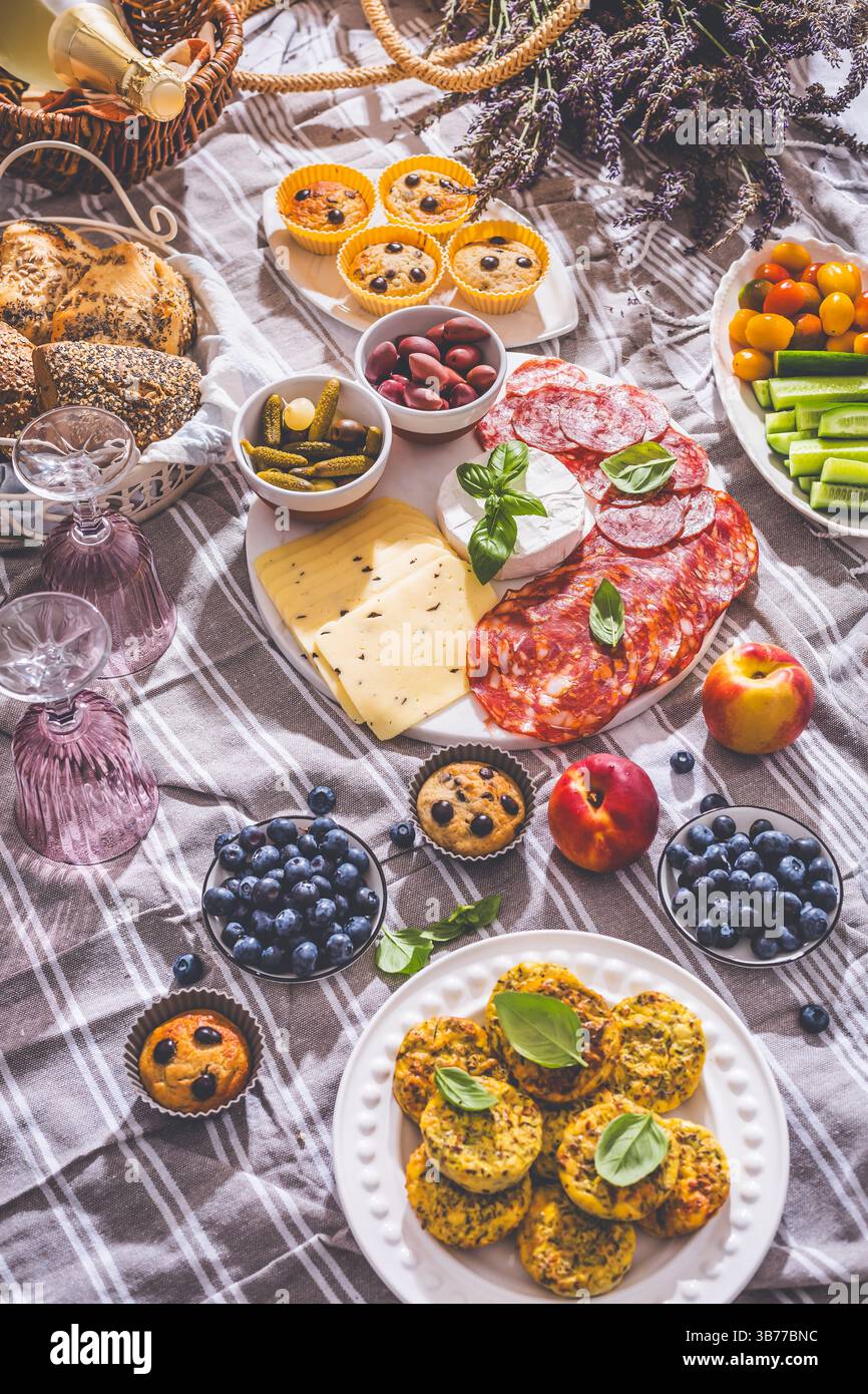 Picknick, Vorspeisen und Käse- und Fleischplatte mit süßen und herzhaften Muffins und Obst Stockfoto