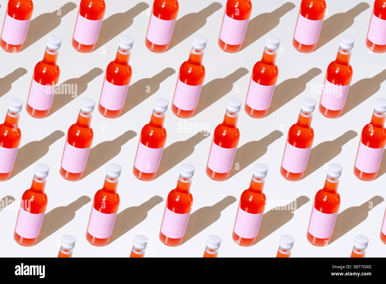 Muster lebendiger Getränkeflaschen mit pinkfarbenen Etiketten und künstlerischen Schatten – ideal für Branding- und Werbeprojekte. Stockfoto