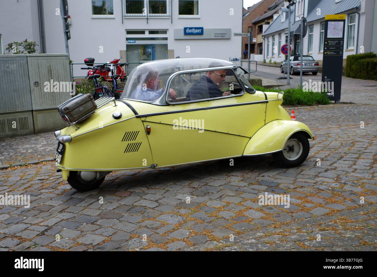 Bad Bentheim, Deutschland - 4. Mai 2025 Ein niedlicher gelber Messersmitt Kabinenroller KR200 von 1958 fährt vom Oldtimer-Treffen in Bad Bentheim weg Stockfoto