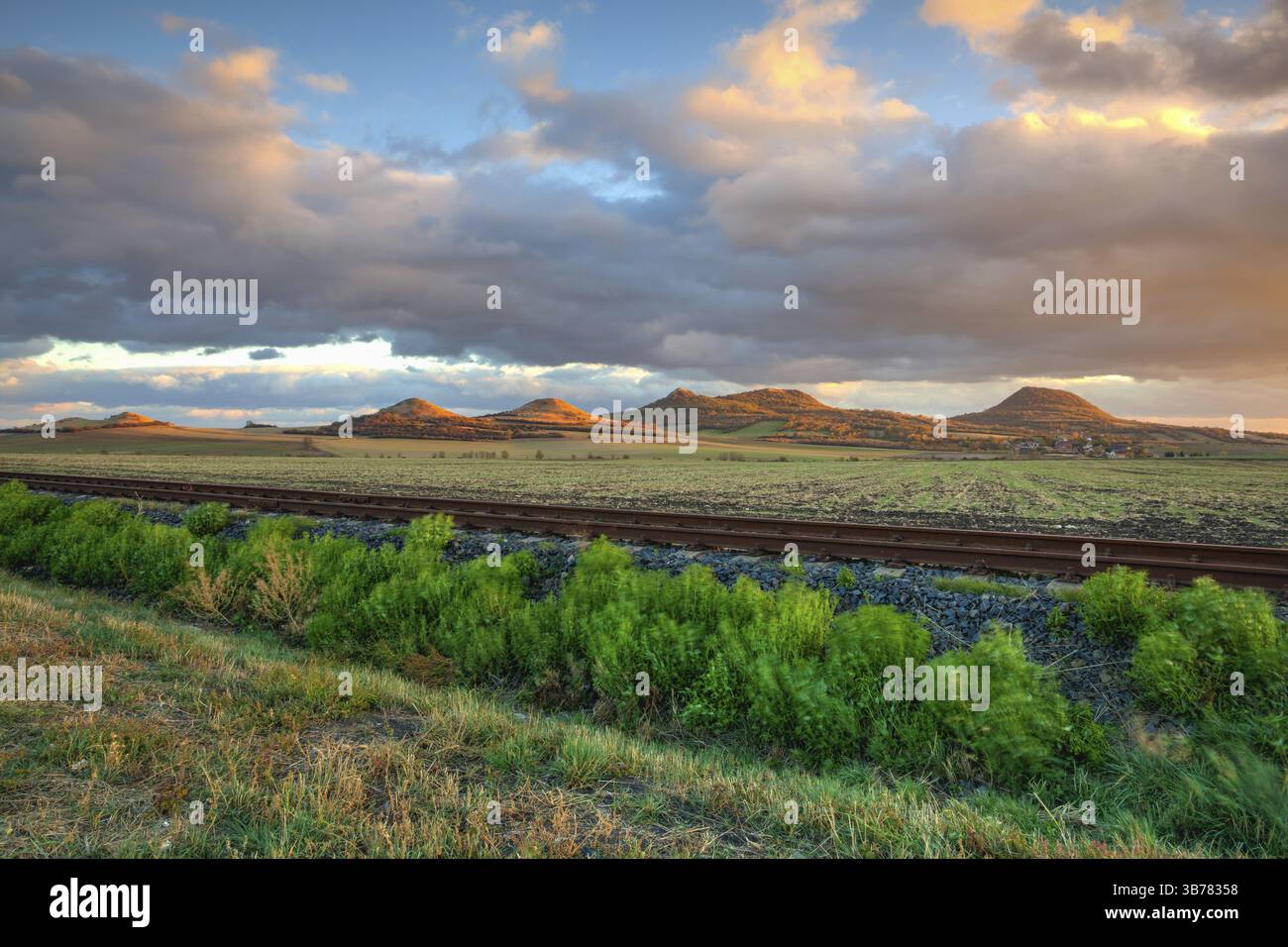 Single Bahnstrecke bei Sonnenuntergang, zentrale Böhmisches Mittelgebirge, Tschechische Republik. Die Bahn in der Natur Park Central Böhmisches Mittelgebirge, Tschechische Republik. HDR Stockfoto