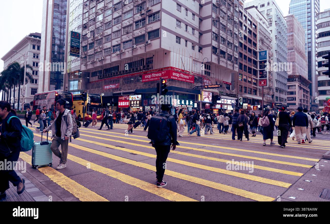 Pendlerströme überqueren die Nathan Road in Tsim Sha Tsui Stockfoto