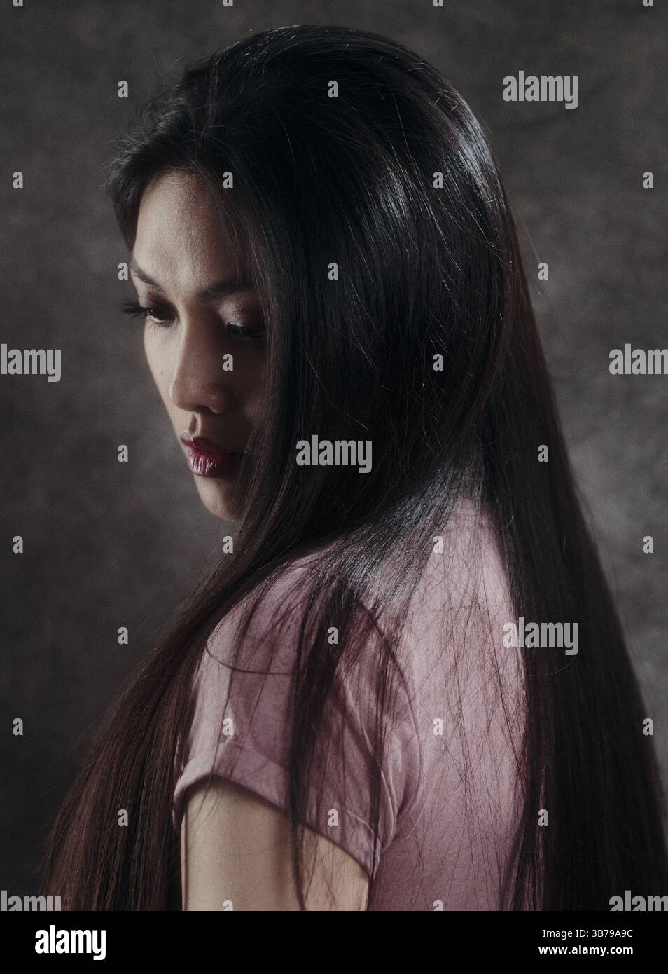 Nachdenkliche Frau mit langen dunklen Haaren Stockfoto