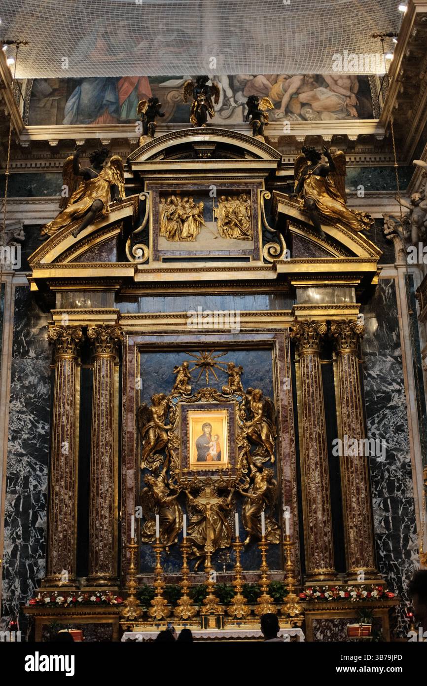 Goldenes Symbol des Salus Populi Romani, flankiert von kunstvollen korinthischen Säulen, vergoldeten Skulpturen und dekorativen Marmorwänden in der Basilika Santa Maria Major Rom Italien. Hochwertige Fotos Stockfoto