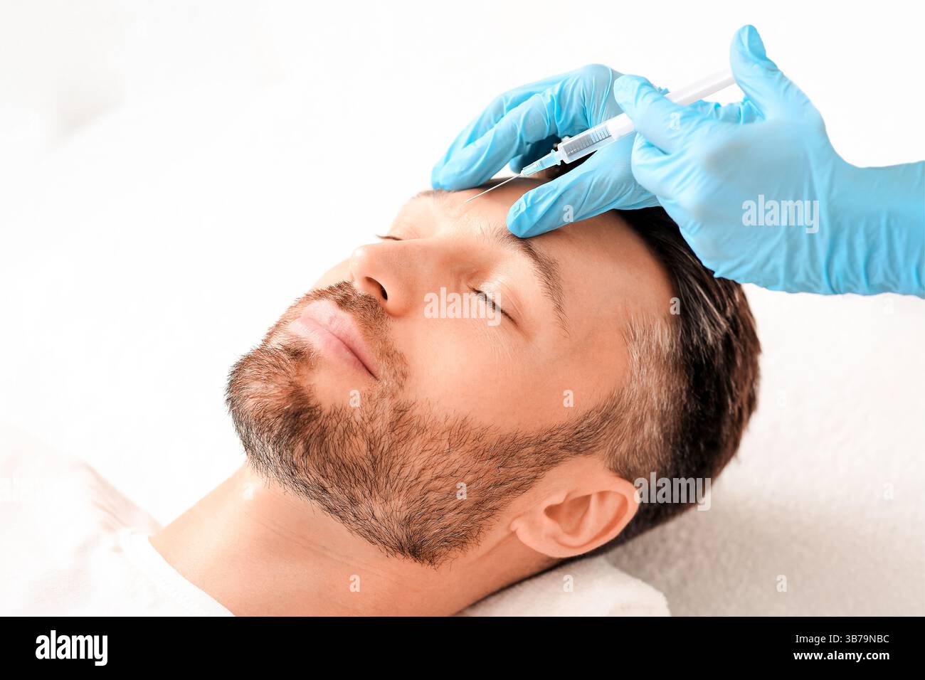 Kosmetologe Injektion Füllstoff zwischen Mann Brauen gegen Stirnrunzeln Stockfoto