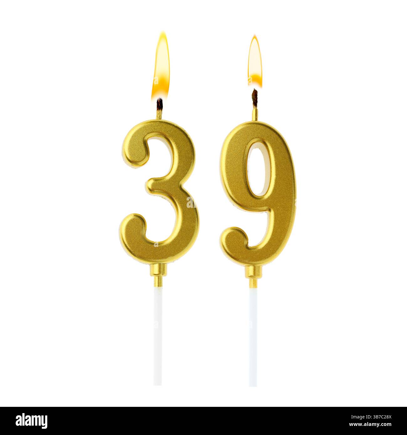 Brennende goldene Kuchenkerzen, die Nummer 39 auf weißem Hintergrund bilden. Festliche Dekoration zum Geburtstag oder zu einem anderen besonderen Datum Stockfoto