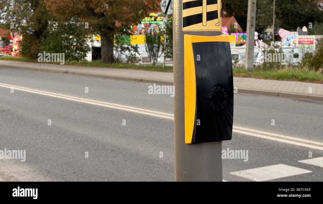 Aktivierungstaste für urbanen Crosswalk mit blindenschrift an stark frequentierten Straßenkreuzungen in moderner Stadtumgebung mit Herbstlaub. Stockfoto