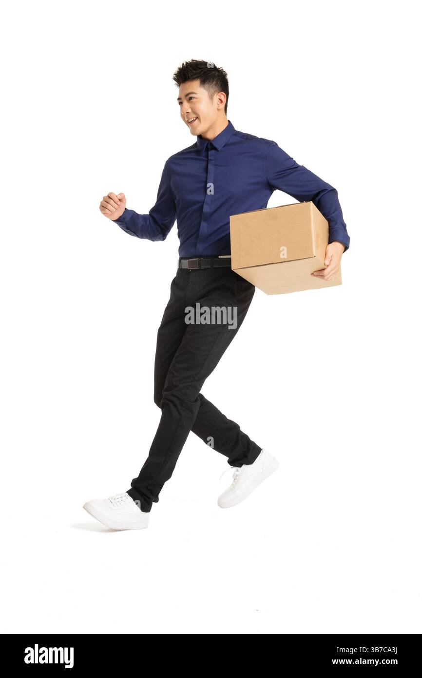 Ein Geschäftsmann, der mit einer Verpackungsbox in der Hand vorstürzt und Dringlichkeit und Effizienz vermittelt Stockfoto