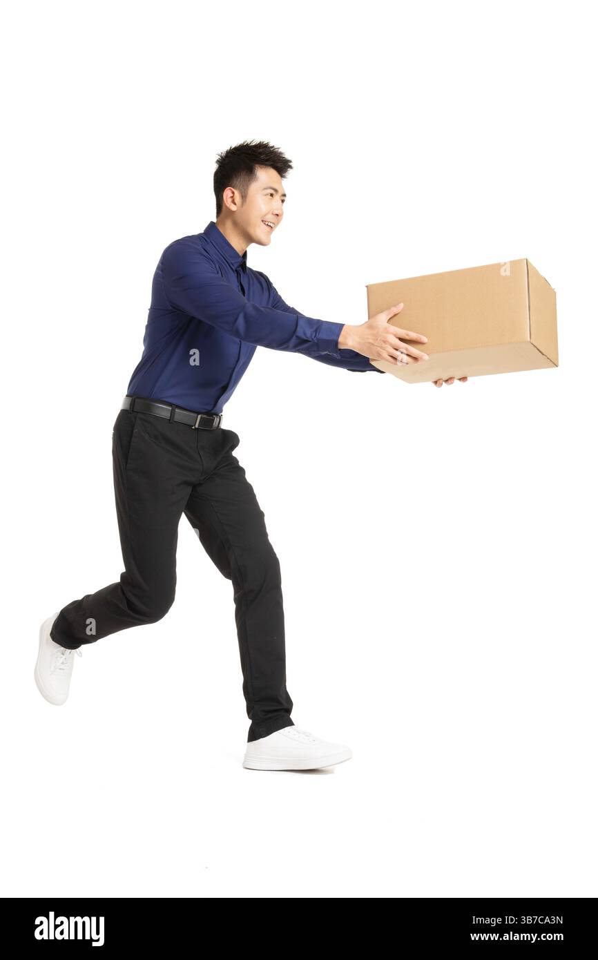 Ein Geschäftsmann, der mit einer Verpackungsbox in der Hand vorstürzt und Dringlichkeit und Effizienz vermittelt Stockfoto