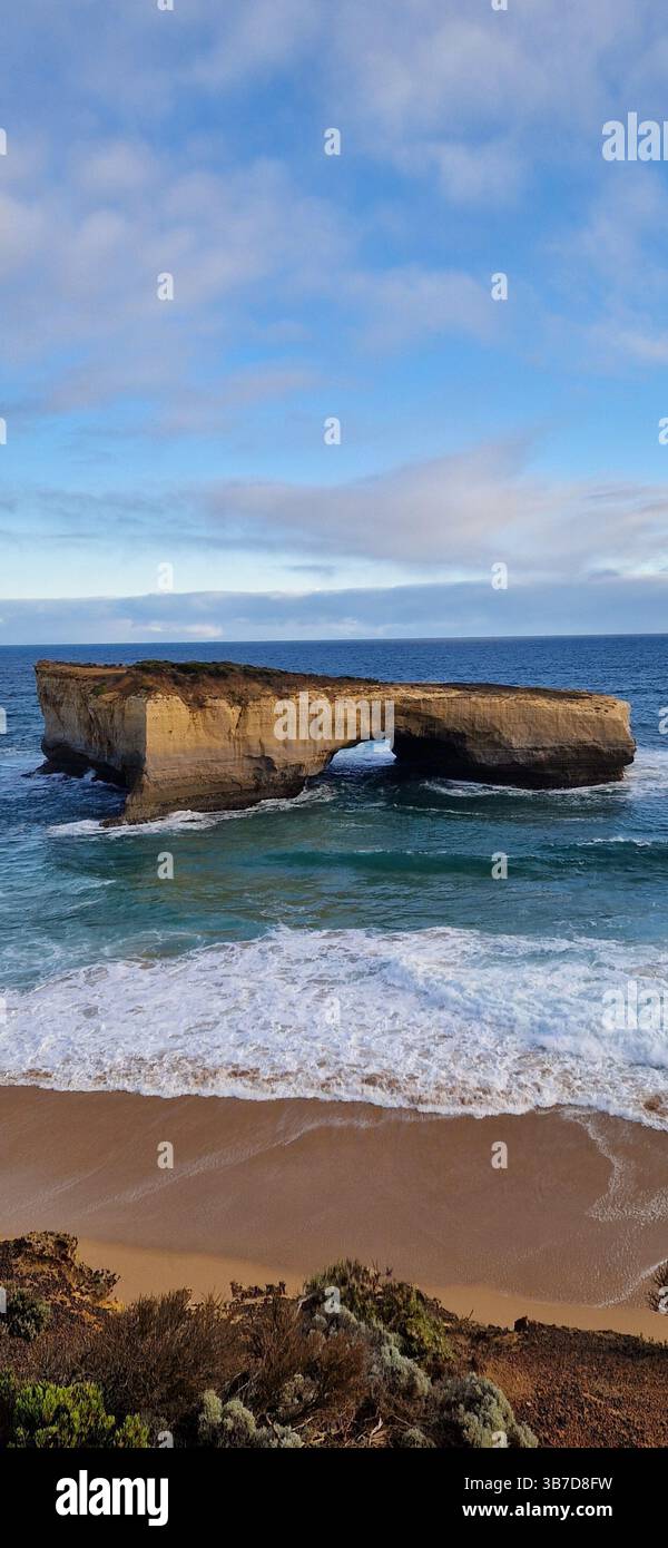 Rock, Sea & Sand Australia. Eine markante Felsformation, die sich aus dem pulsierenden blauen Meer vor der Küste Australiens erhebt, umgeben von kristallklarem Wasser und endlosem Himmel, ein dramatisches Zeichen der rauen Schönheit der Natur - Smartphone-aufgenommenes Stockfoto