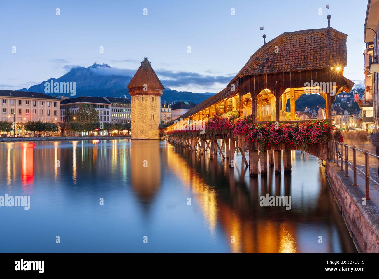 Luzern, Schweiz mit der Kapellbrücke und dem Wasserturm über der Reuss in der Dämmerung. Stockfoto