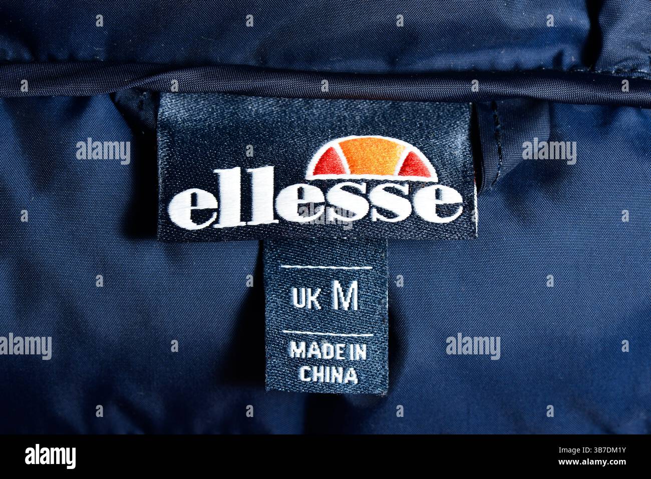 Ellesse Sportjacke Etikett mit UK-Größe M und Made in China-Kennzeichnung, die den Ursprung der Kleidung, das Markenzeichen und die Größenangaben anzeigt Stockfoto