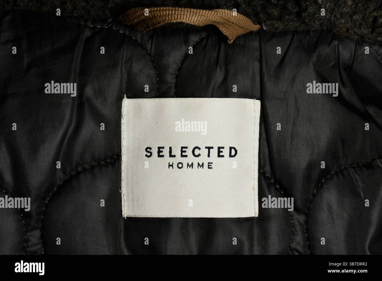 Ausgewähltes Homme-Label, das auf einer Jacke genäht ist, zeigt Markenmarkendetails auf der Oberbekleidung des modernen Herrenmode-Labels Stockfoto