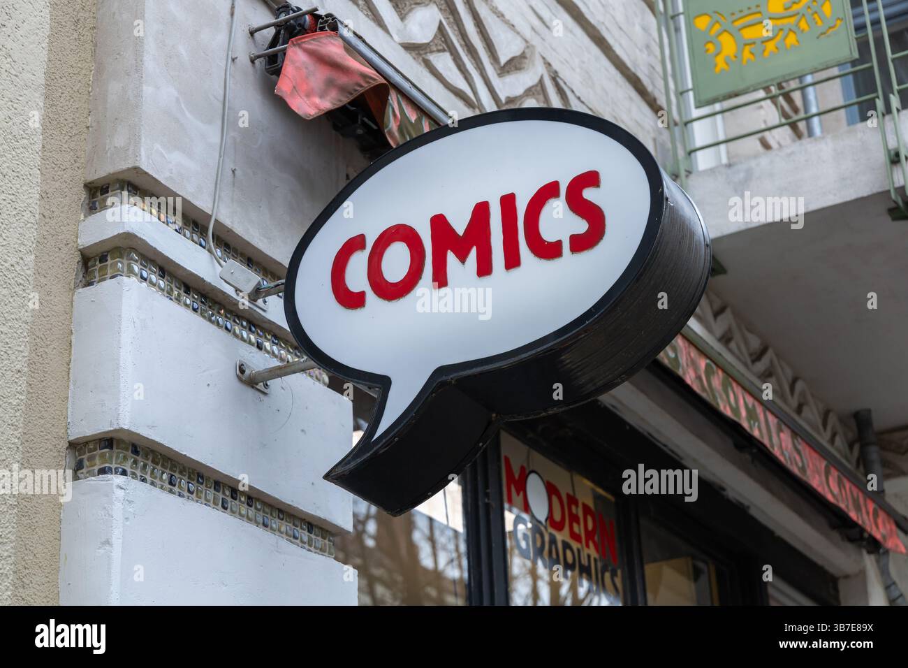 Das Logo eines Comic-Shops in Form einer Sprechblase an einer Gebäudefassade mit auffälligen roten „COMIC“-Buchstaben lädt Besucher zum Erkunden der grafischen Nove ein Stockfoto