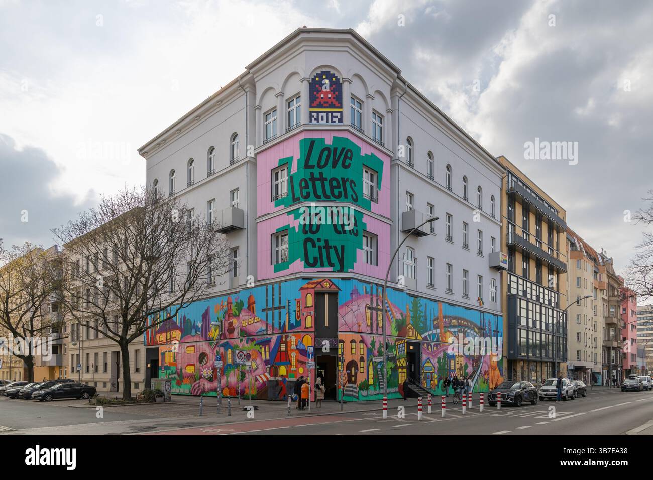 Ein farbenfrohes Wandgemälde mit dem Text „Love Letters to the City“ ziert ein Eckgebäude von Urban Nation in Berlin und zeigt lebendige urbane Straßenkunst Stockfoto