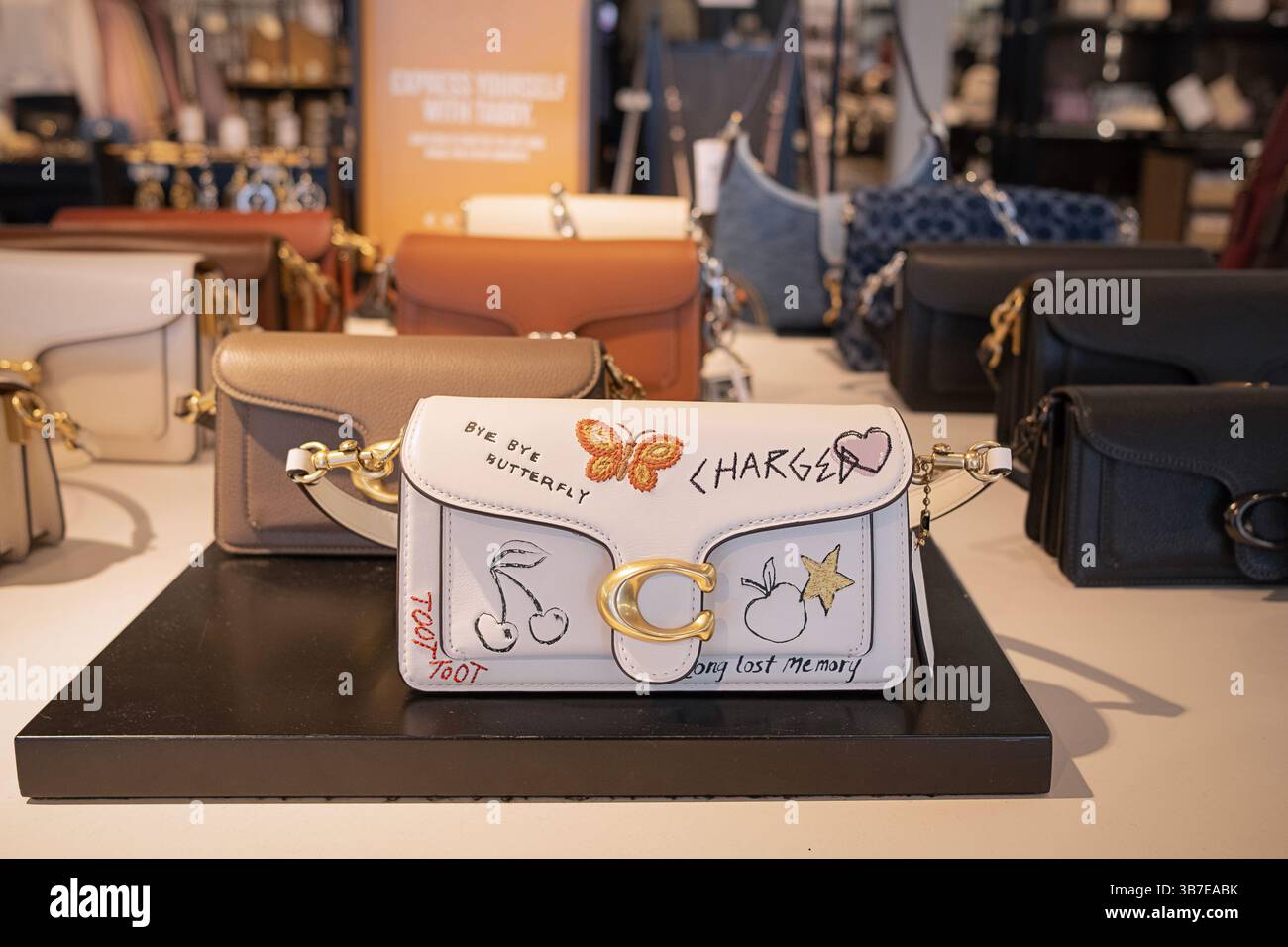 Coach-Tasche im Tabby-Stil mit Aufschrift, die ein bisschen wie Graffiti aussieht. Im Coach Outlet Store im Deer Park Outlet Mall in Long Island, New York. Stockfoto