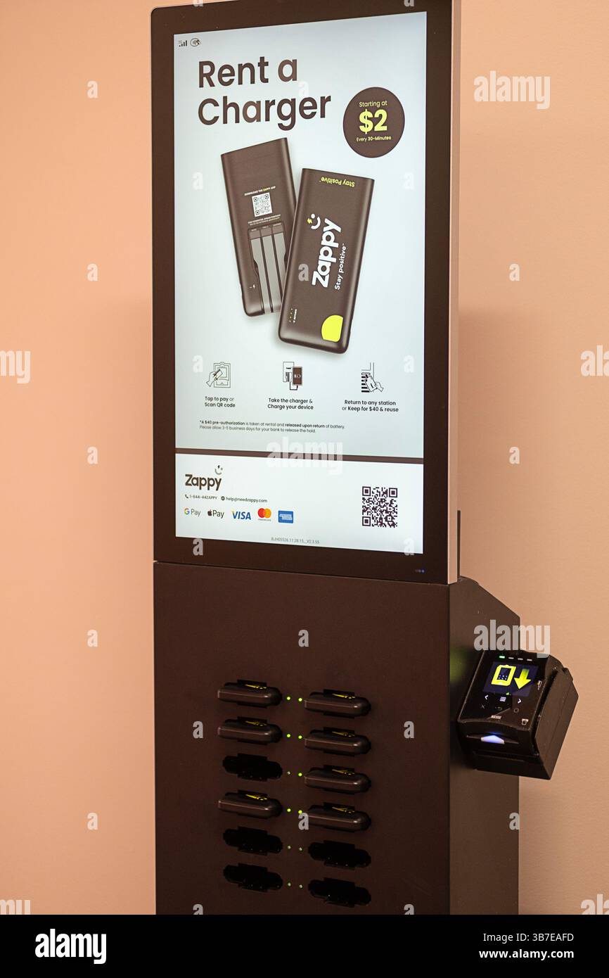 Ein Ladegerät für Mobiltelefonbenutzer mieten. Im Deer Park Outlet Mall in Long Island, New York. Stockfoto