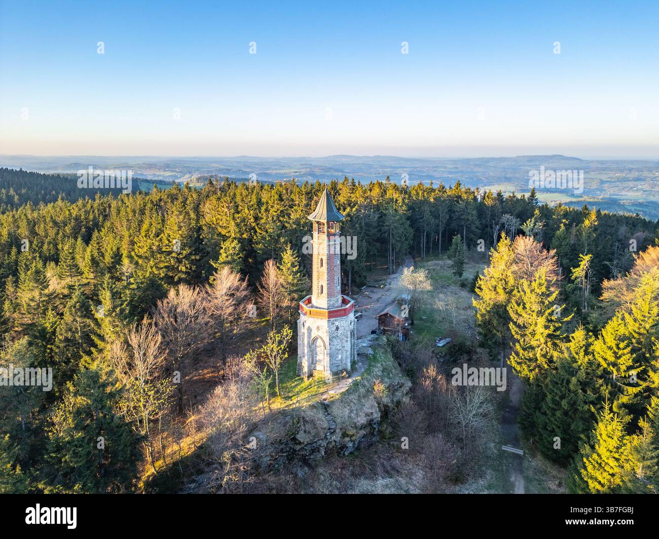 Der Stepanka Aussichtsturm steht hoch im lebhaften Frühlingsgrün des Isergebirges in Korenov, Tschechien, und fängt die Ruhe der frühen Morgenatmosphäre ein. Stockfoto