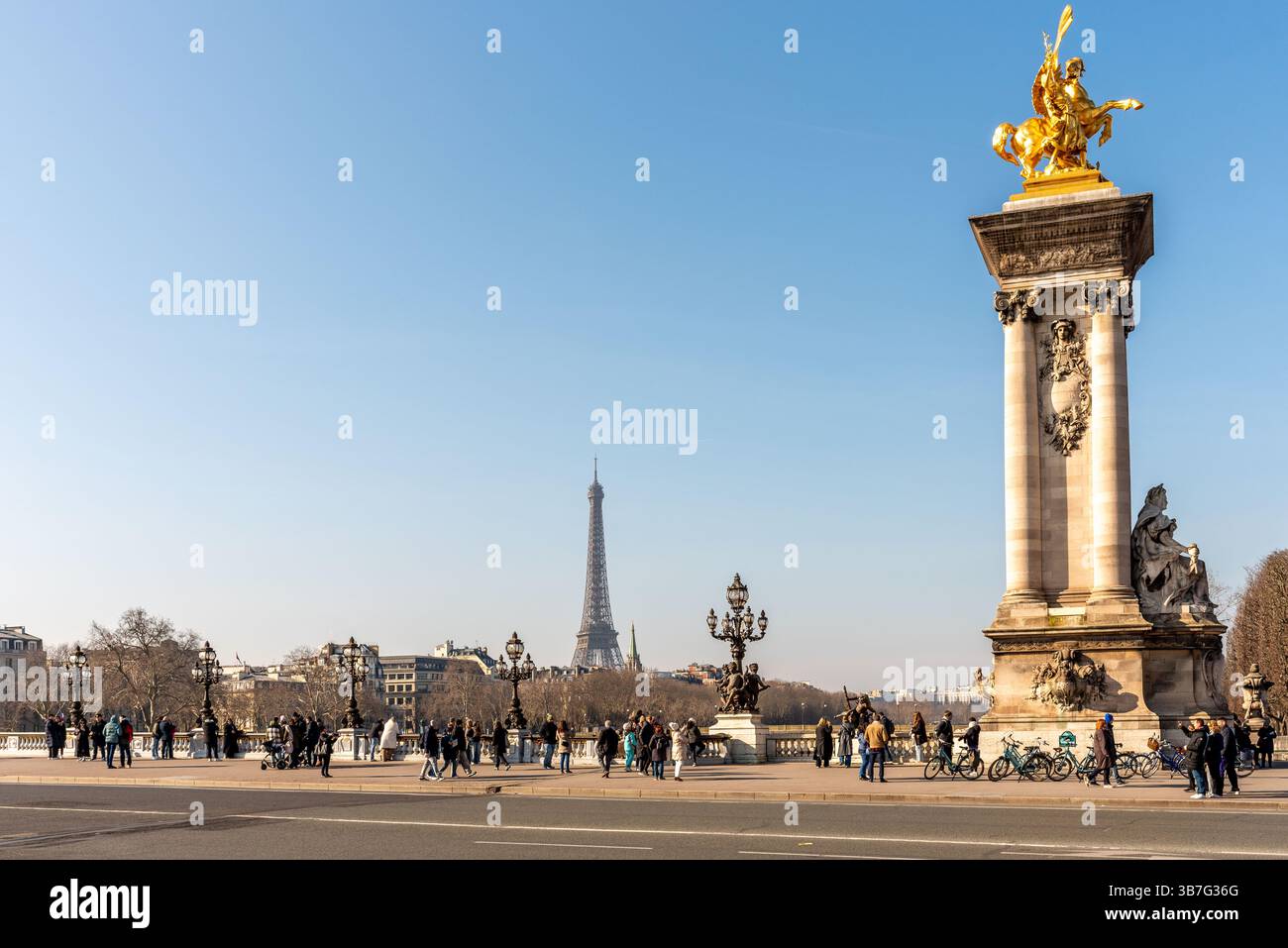Touristen machen Fotos vom Eiffelturm von der Alexandre III Brücke an einem sonnigen Tag. Stockfoto
