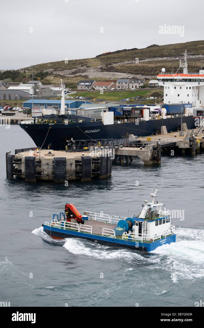 Das Shetland Workboat Bagheera führt über den Hafen von Lerwick mit der NorthLink Ferries Fähre für Nutzfahrzeuge, die MS Hildasay hinterlegt Stockfoto