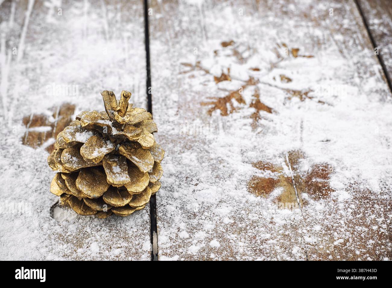 Zedernturm in Goldfarbe auf einem verschneiten hölzernen Hintergrund Stockfoto