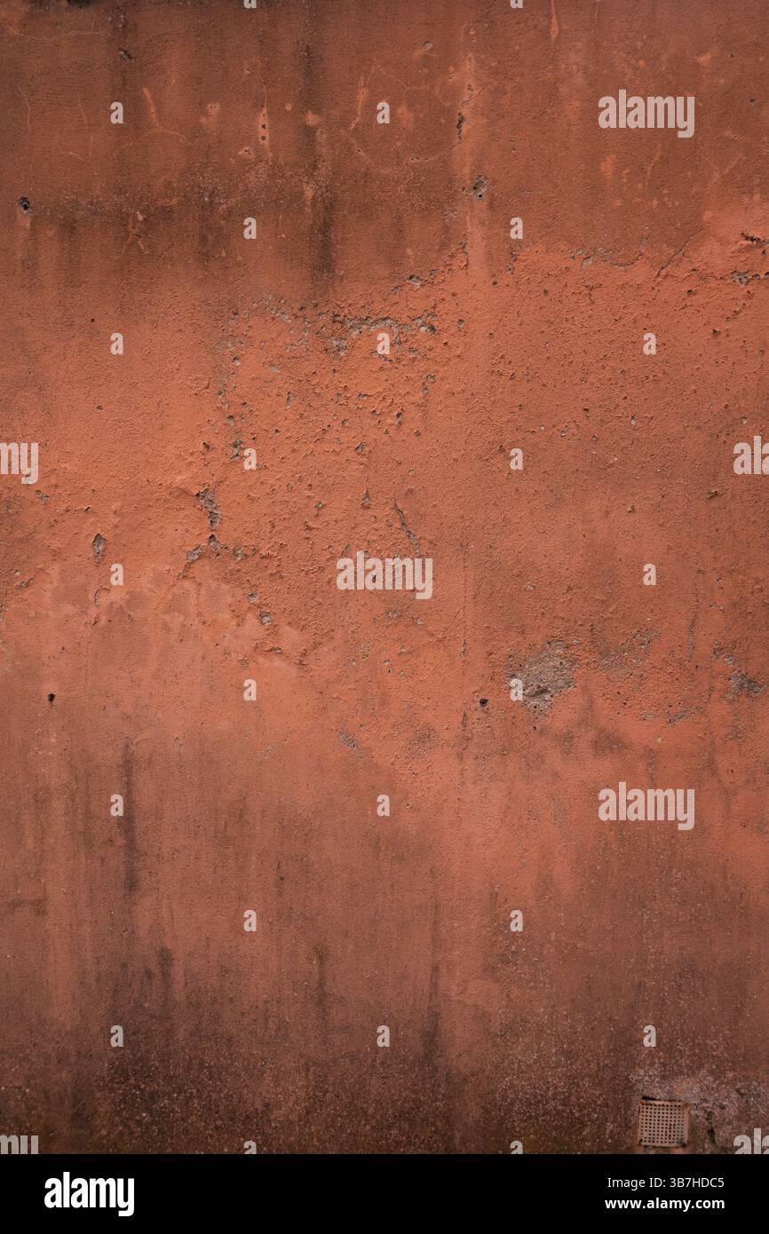 Rote Betonwand in Not und Risse Stockfoto