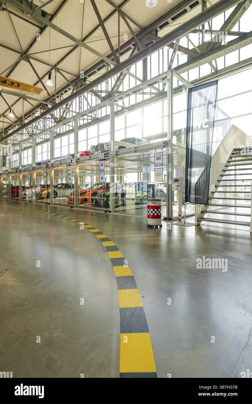 Langer Korridor mit Glasgarage und mehreren Autos, minimalistisches und modernes Layout, Motorworld Böblingen, Deutschland, Europa Stockfoto