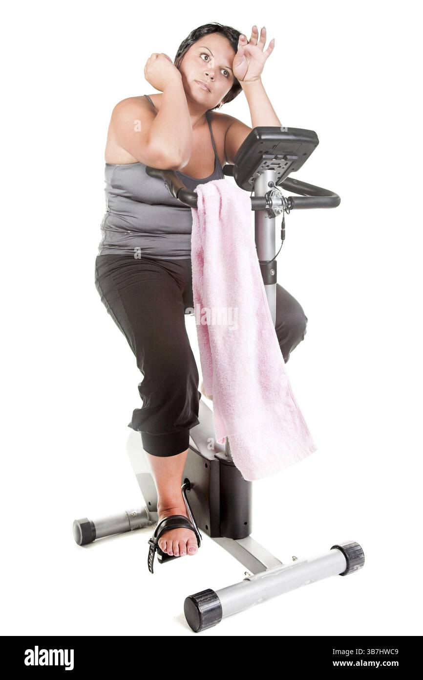 Fette Frauen trainieren auf dem Fahrrad Stockfoto