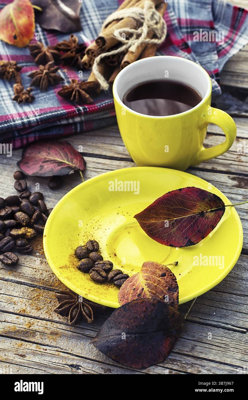 Gelbe Tasse schwarzen Kaffee auf Hintergrund mit warme Decke mit Herbst gestreut Stockfoto