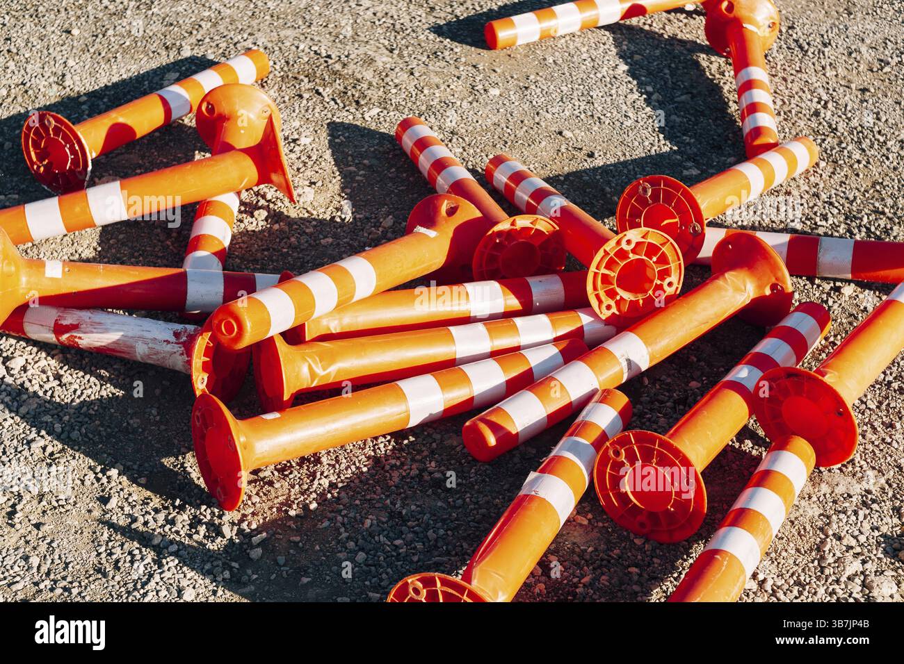 Auf der Straße sind orangefarbene Straßenbegrenzer aufgestapelt. Stockfoto