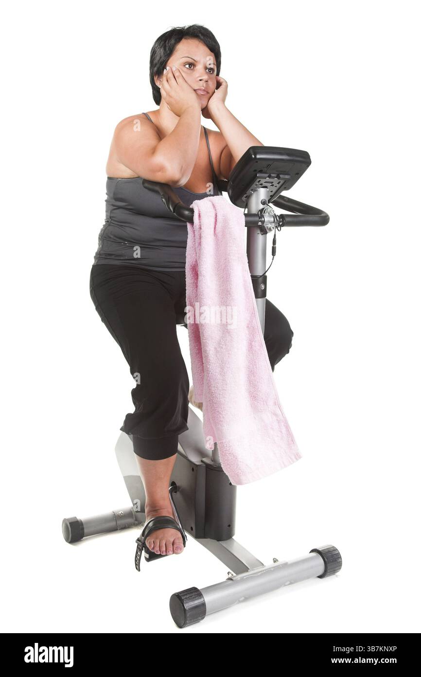 Fette Frauen trainieren auf dem Fahrrad Stockfoto