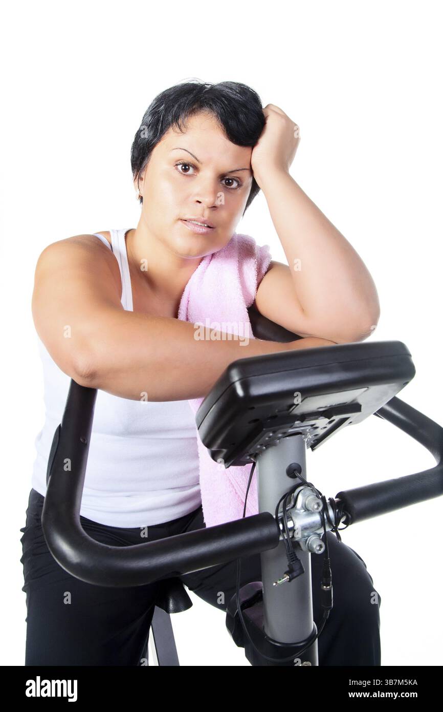 Fette Frauen trainieren auf dem Fahrrad Stockfoto