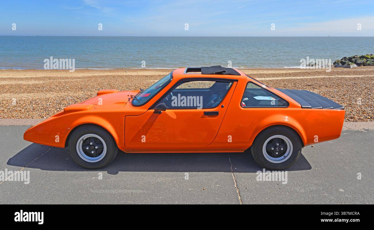 Klassischer orangefarbener Clan Crusader parkt am Strand und Meer im Hintergrund Stockfoto