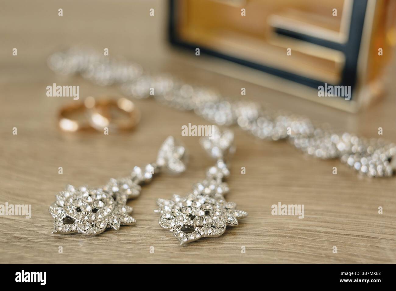 Nahaufnahme von Ohrringen mit Goldringen und Armband auf verschwommenem Hintergrund. Stockfoto