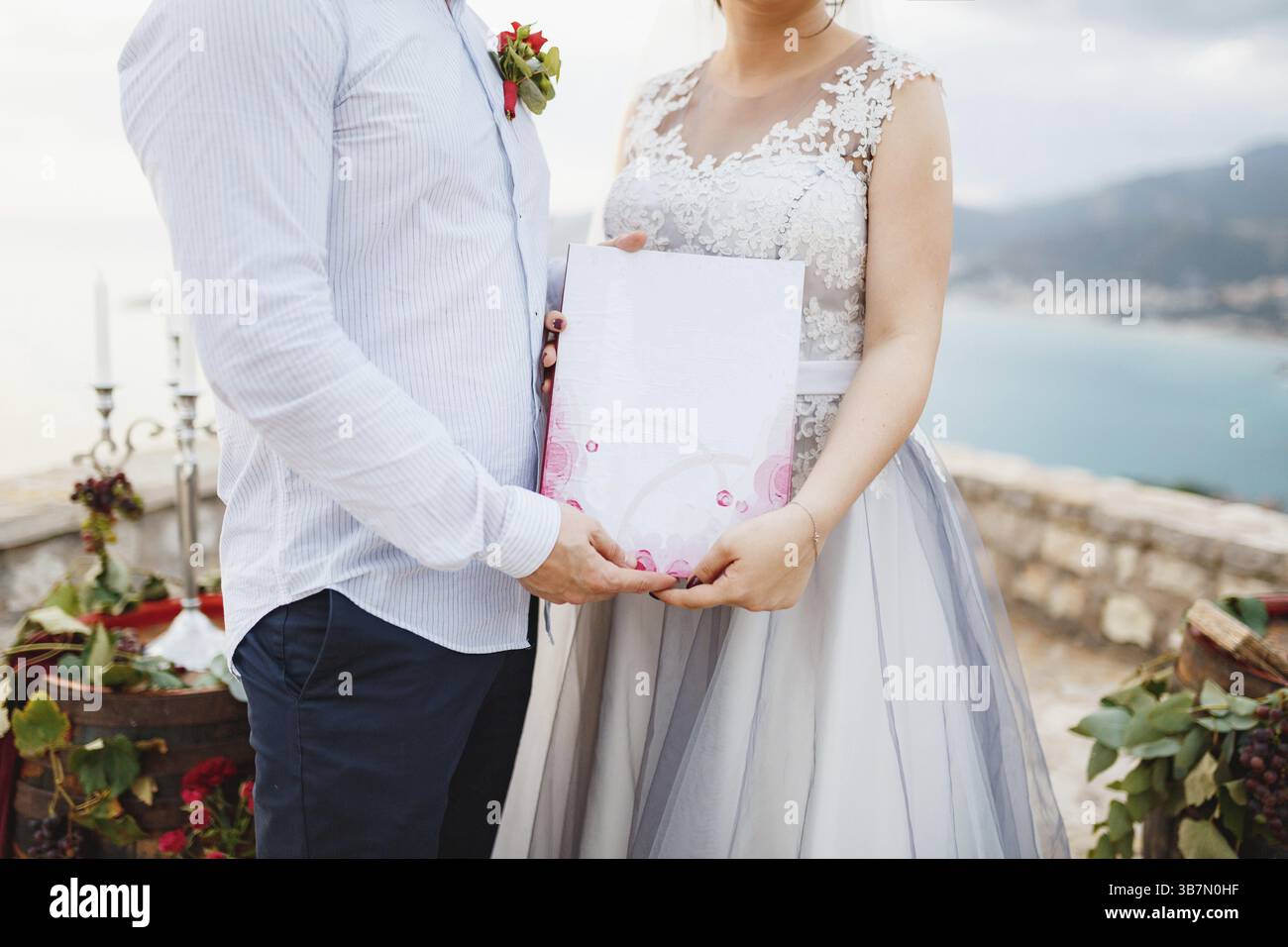 Die Braut und der Bräutigam nehmen eine Heiratsurkunde in den Händen, Nahaufnahme. Stockfoto