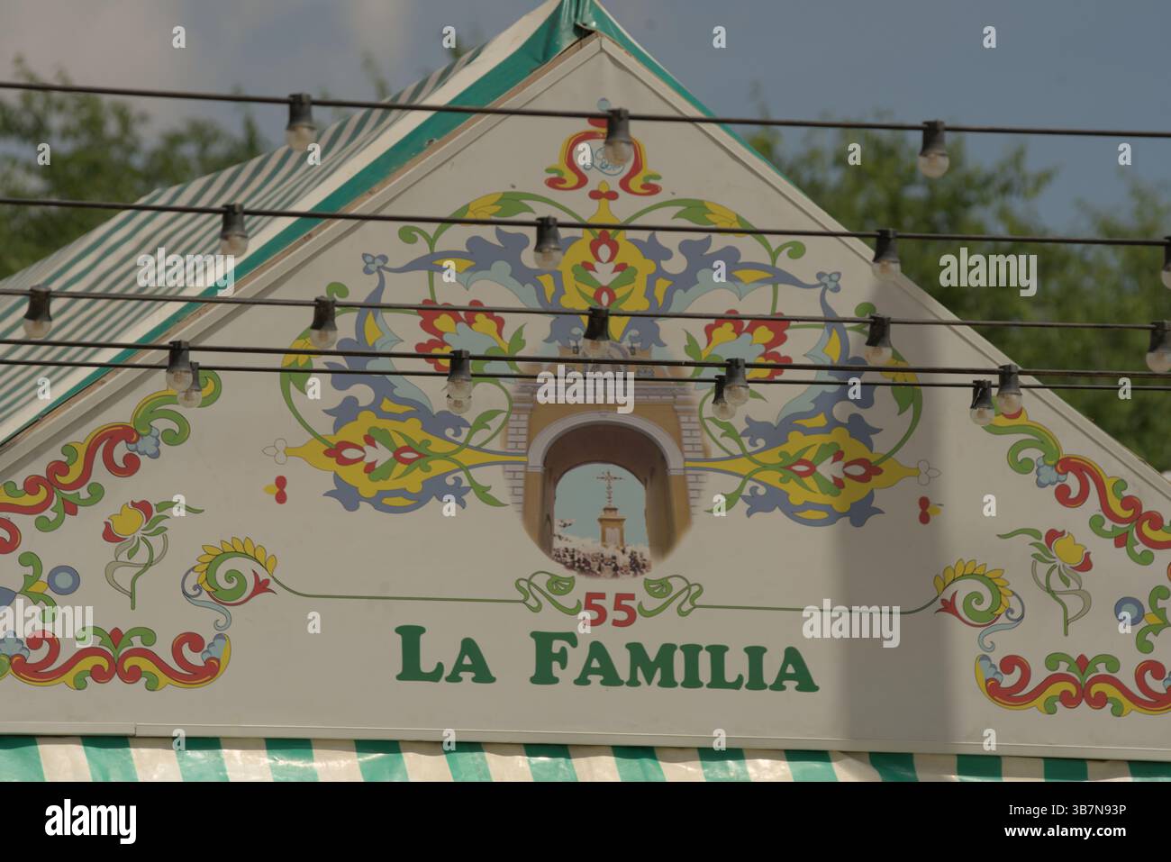 Handgemalte Caseta-Fassade „La Familia“ in La Feria de Sevilla 2025, die andalusische Familientraditionen und festliche Kunst symbolisiert. Feria de Sevilla Stockfoto