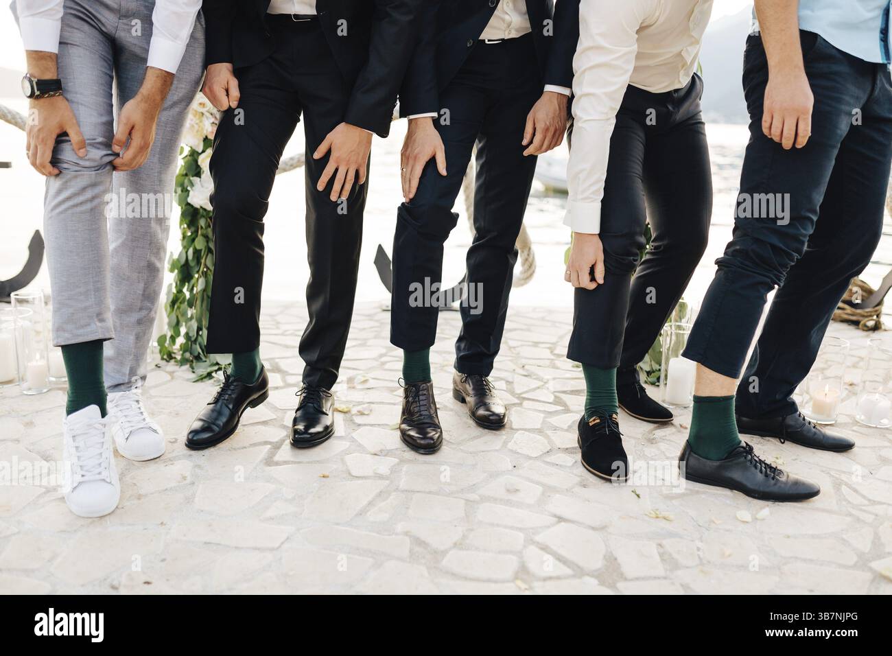 Der Bräutigam und die besten Männer zeigen, dass sie die gleichen grünen Socken tragen. Stockfoto