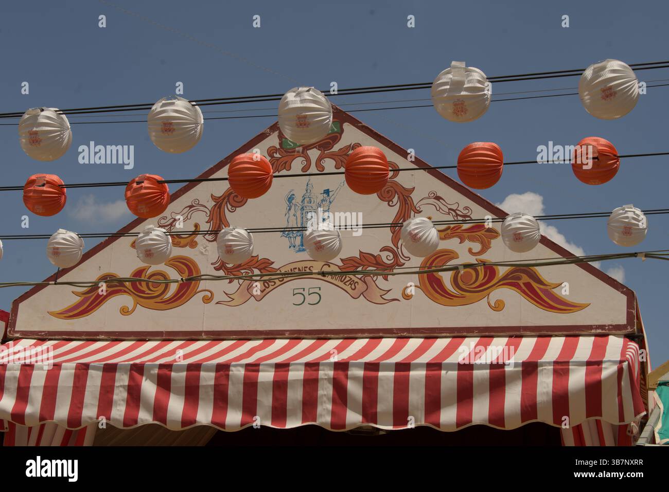 Dekorierte Caseta-Fassade mit rot-weißen Streifen und Laternen im La Feria de Sevilla 2025.Feria de Sevilla, Spanien Stockfoto
