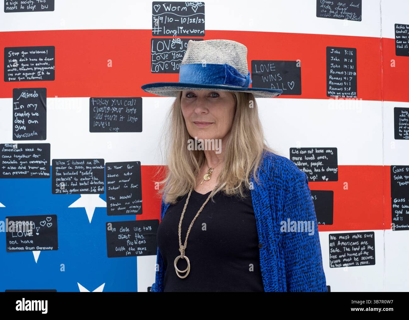 19. Mai 2024, Washington, District of Columbia, USA: Die renommierte bildende Künstlerin Suzanne Brennan Firstenberg posiert für ein Foto mit ihrer Kunstinstallation „Aliable Right to Life“ auf dem Freedom Plaza in Washington, D.C. die Installation zeigt eine massive amerikanische Flagge, die aus den Namen von 1.039 Massenschiessopfern geschaffen wurde und ein Bild der Unabhängigkeitserklärung überlagert. Weitere Elemente sind ein Originalgedicht, das sich an alle Opfer von Waffengewalt richtet, und ein kreisförmiges Wandgemälde, auf dem Besucher persönliche Geschichten erzählen können. (Kreditbild: © Probal Rashid/ZUMA Press Wire) Stockfoto