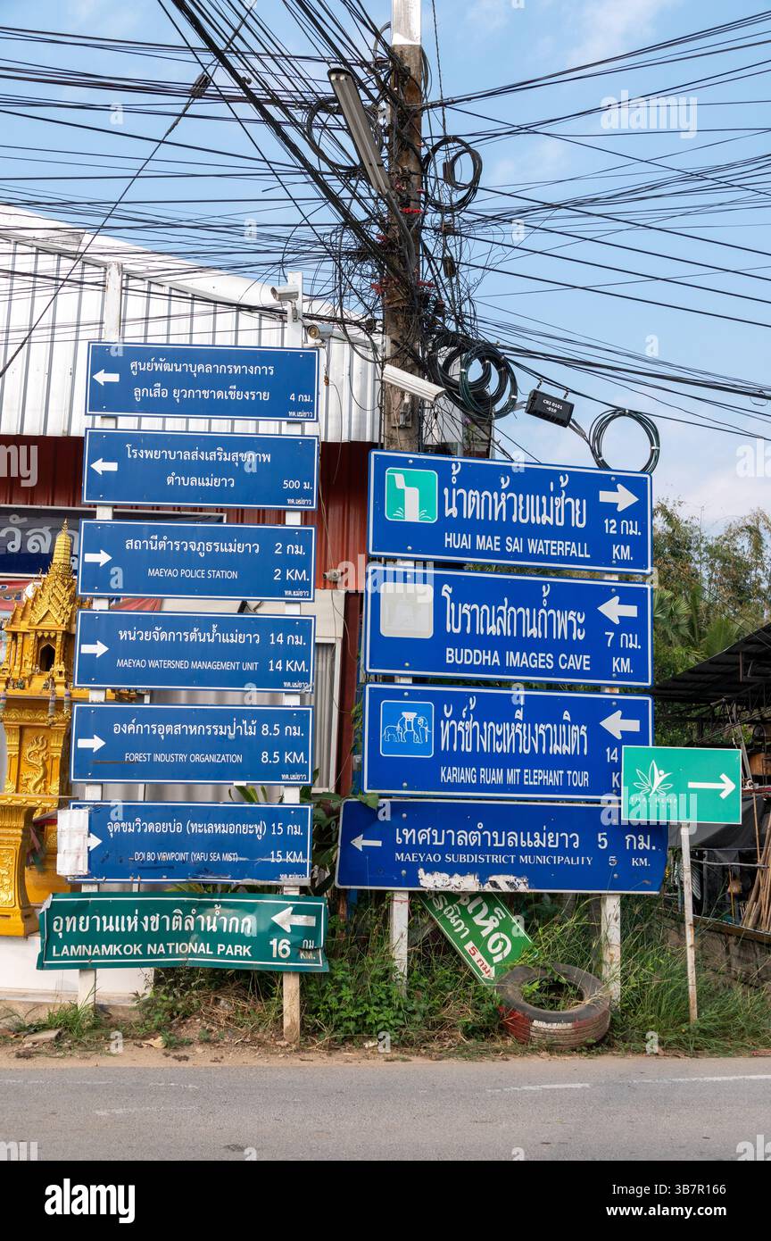 Ein Verkehrszeichen mit einer Mischung aus thailändischen und englischen Wörtern an einer T-Kreuzung im Dorf Ban Sai Mun in der Nähe von Mae yao im Bezirk Mueang Chiang Rai, Stockfoto