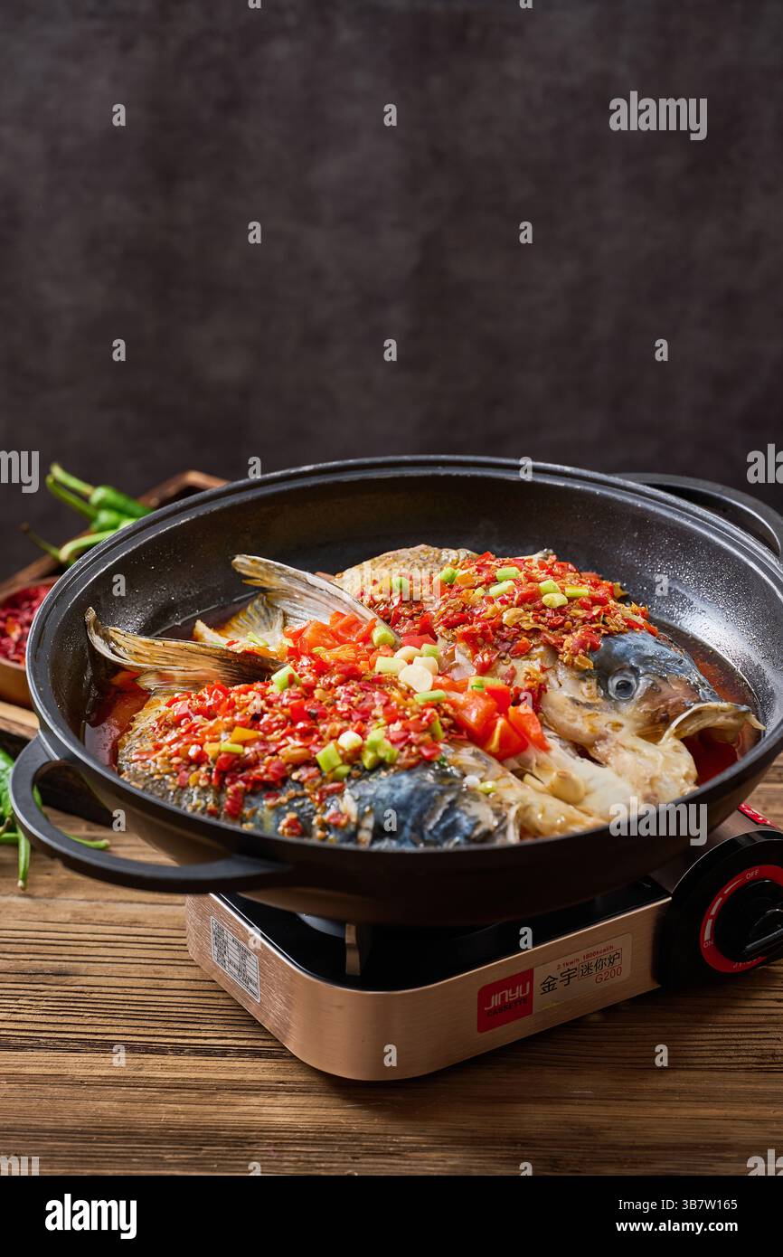 Gedämpfter Fischkopf mit gewürfelten heißen roten Paprika ，Chinesische Hunan-Küche - gehackter Paprikakopf 剁椒鱼头 Stockfoto