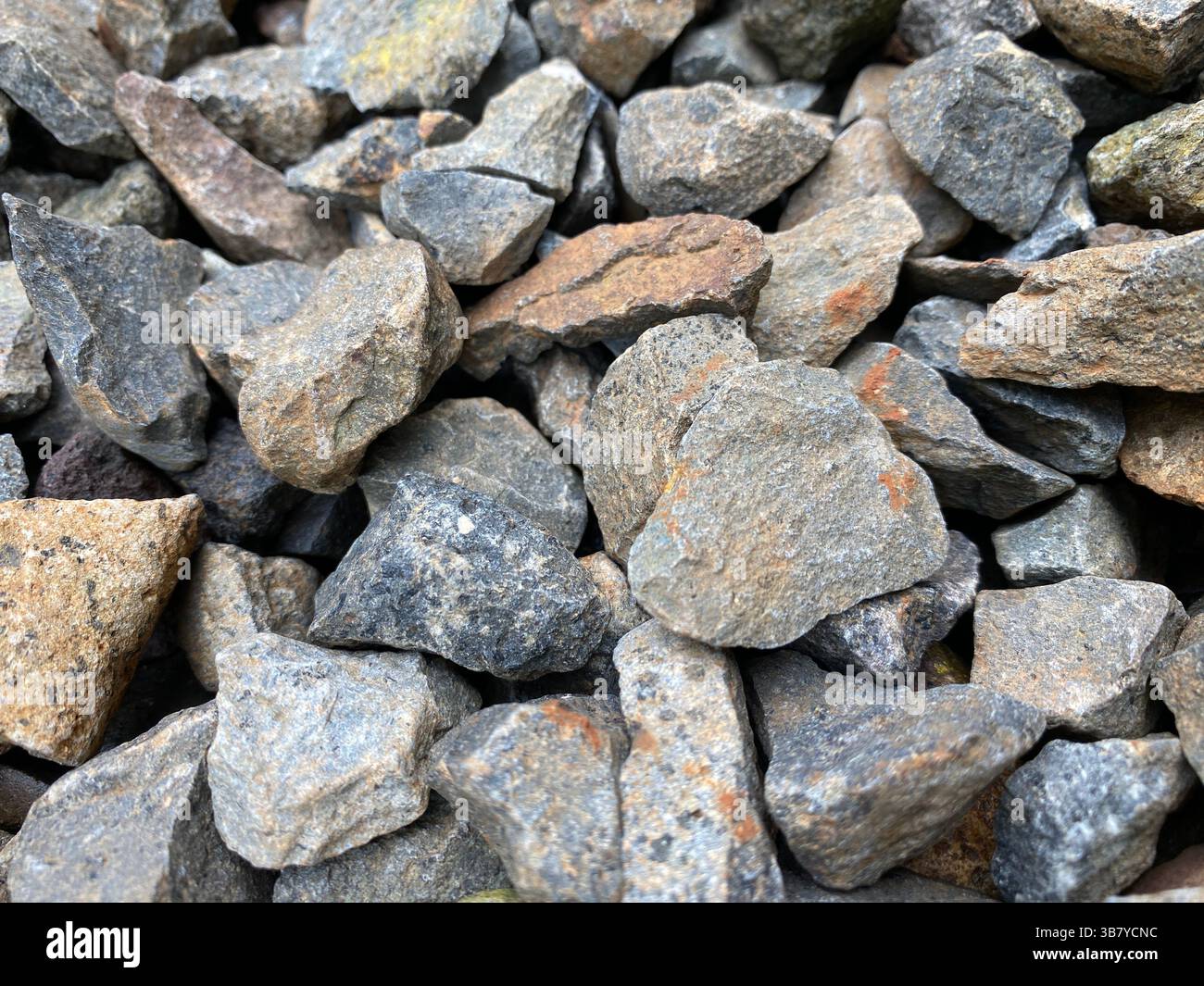 Granit zerquetschter Stein aus massivem Gestein mit körniger Struktur, Hintergrundstruktur des Baumaterials Stockfoto