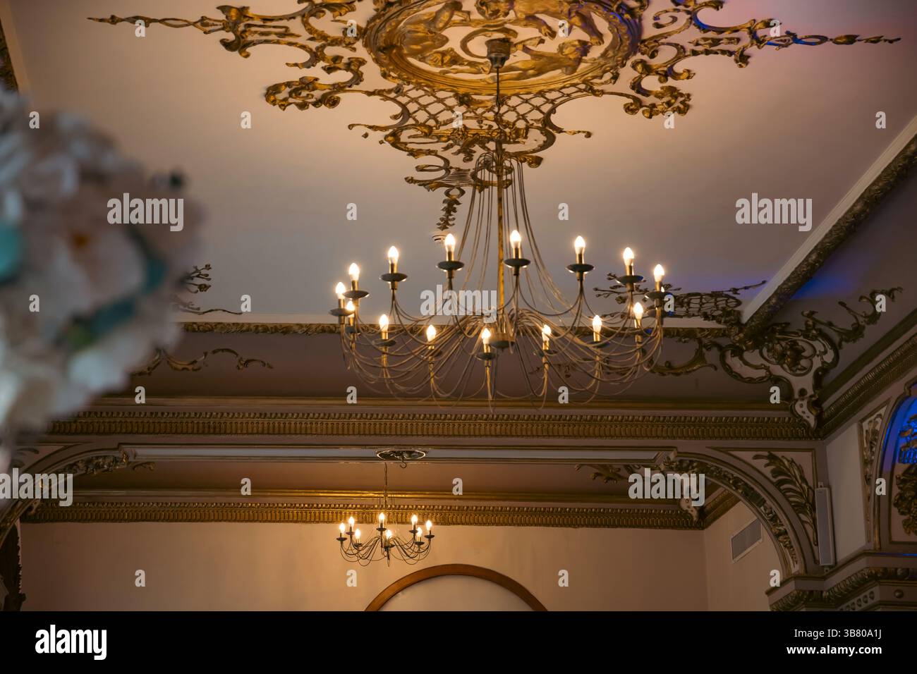 Vintage-Kronleuchter im Inneren eines eleganten Zimmers, schöner luxuriöser, teurer Kronleuchter, der von der Decke hängt Stockfoto