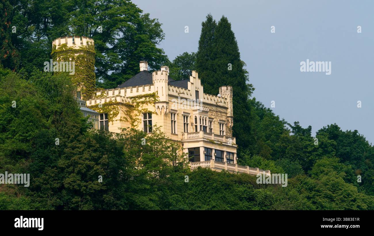 Historisches Schlossgebäude umgeben von üppigem Grün auf einem malerischen Hügel Stockfoto