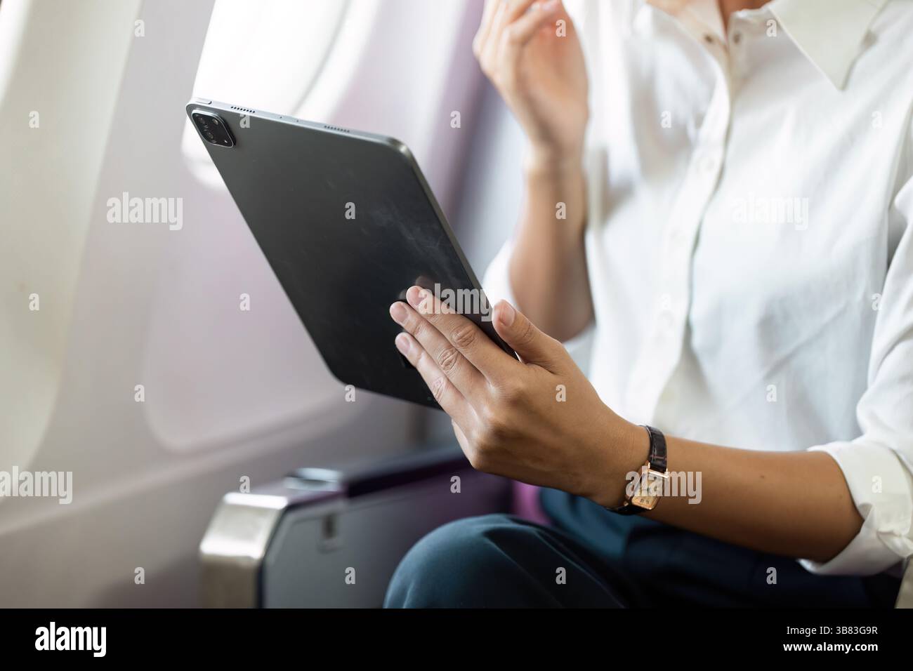 Geschäftsreisen mit einer professionellen Frau mit einem Tablet auf einem Flug Stockfoto